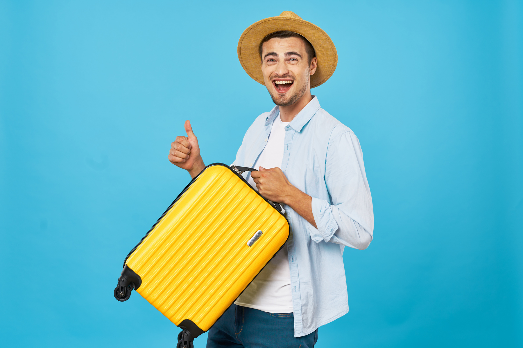 Man Traveler with a Suitcase Shows the Thumb